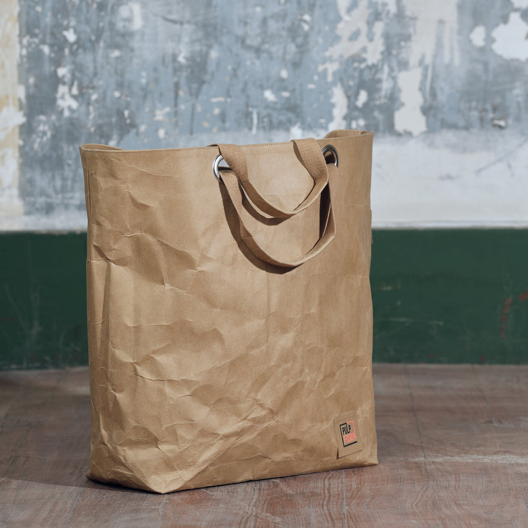 Brown paper bag on a wooden floor with a textured wall in the background
